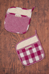 Two red and white checkered pot holders on a wooden surface