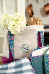 Tote bag with floral design and embroidered logo in a kitchen setting