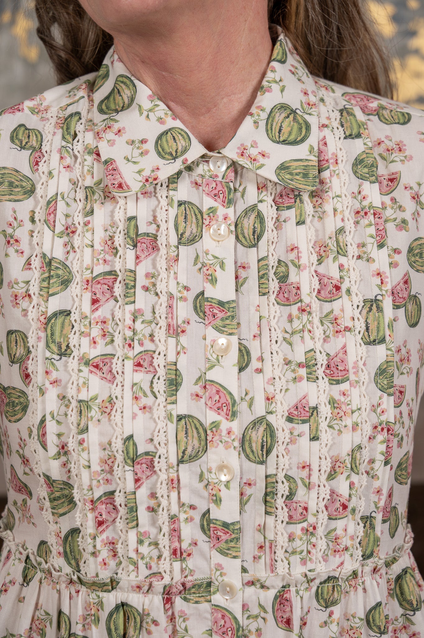 Close-up of a person wearing a floral blouse with watermelon pattern
