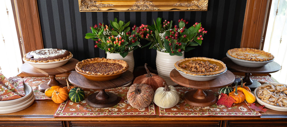 Self-serve Thanksgiving dessert table with pies on stoneware stands
