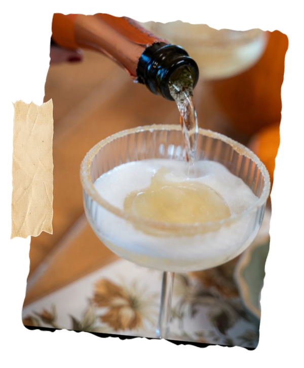 A fall mimosa being poured into a coupe glass